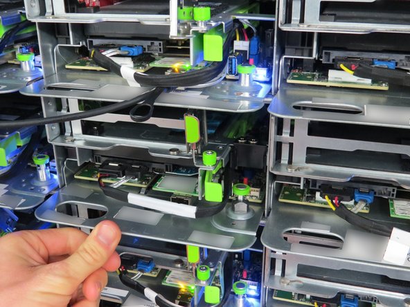 If the green retention plunger is still in the upright position, twist it 90 degrees to release it. This will secure the server.