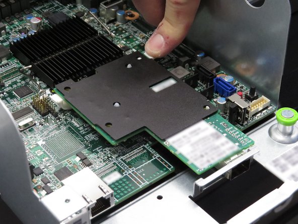 Press down on the four nylon retention tabs / standoffs securing the network interface controller