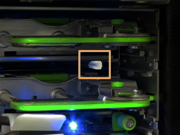 Align the outside edges of the SAS expander board with the nylon guides found underneath the storage tray chassis.