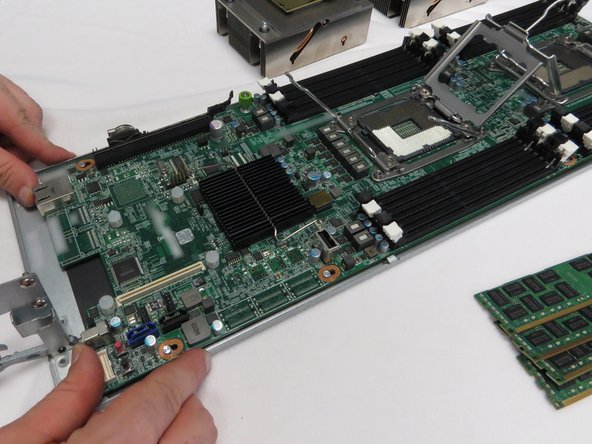 Push the motherboard towards the rear of the sled until resistance is felt.