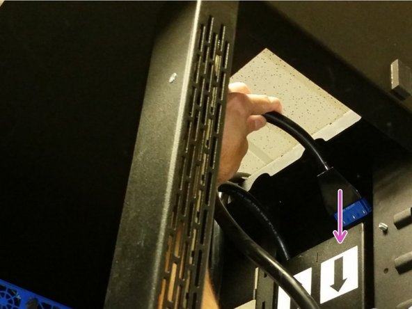 Locate the longer AC power cable (labeled 'BOTTOM' ) and insert into the trough with the arrow pointing down.