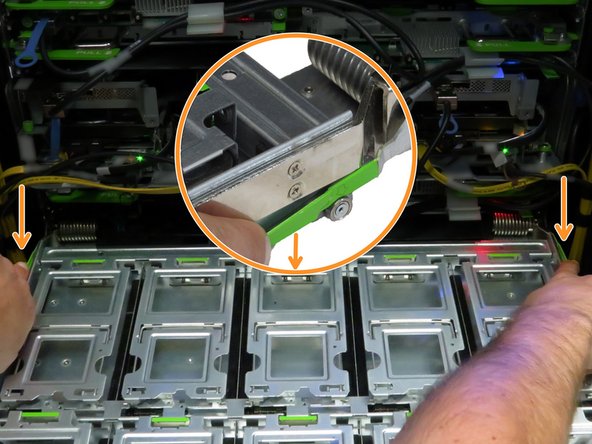 Press down two storage tray locking tabs.