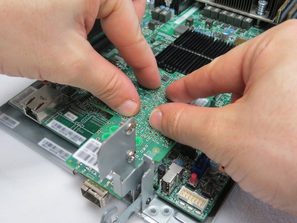 Press the NIC downards, as shown.