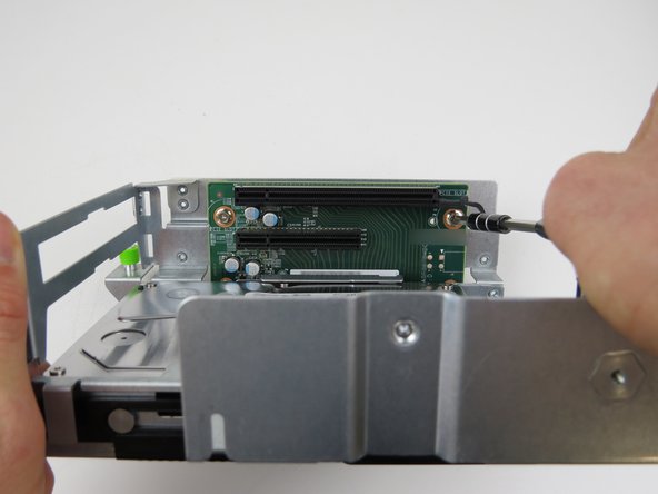 Remove (2) phillips head screws which secure the riser card to the cage.