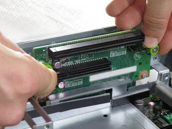 Loosen the two thumbscrews securing the riser card to the riser cage.