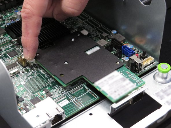 Press down on the four nylon retention tabs / standoffs securing the network interface controller