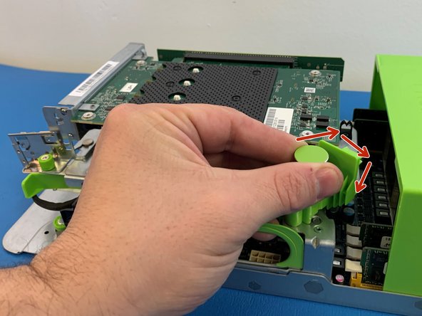 Pull the green retention plunger upwards and then turn 90 degrees clockwise to release the AVA M.2 carrier card.