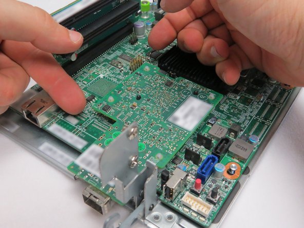 Place your fingers underneath the left side of the NIC PCB as shown.