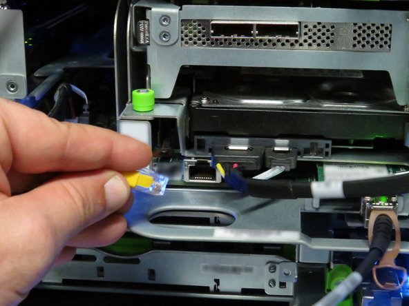 Press the tab on the end of the cable to release it.