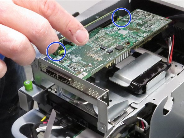Place your thumbs behind the RAID controller circuit board, as shown.