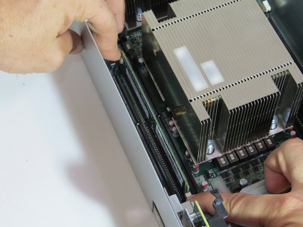 Press the (2) retention tabs on the DIMM slot that seats the failed DIMM.