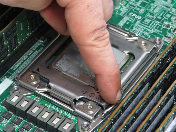 Press the CPU retention bracket lever (nearest the unlock symbol) down and away from the CPU.