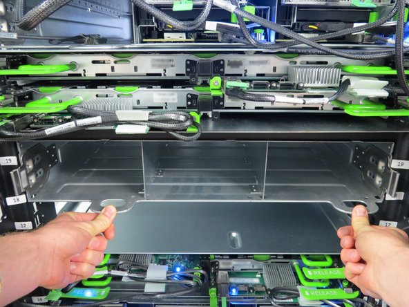 Firmly apply pressure until the metal retention tabs click into place. This indicates that the Cubby sled is secure.