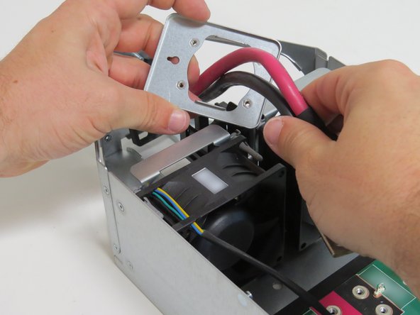 Slide the bus lead retention bracket through the bus lead cables.