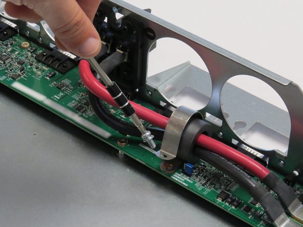 Unscrew one Phillips #2 screw securing the bus lead management clip to the fan controller board.