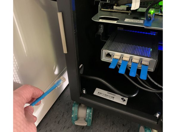 Connect your network cable to the network switch, routing the cable through the adjacent hole in the unit