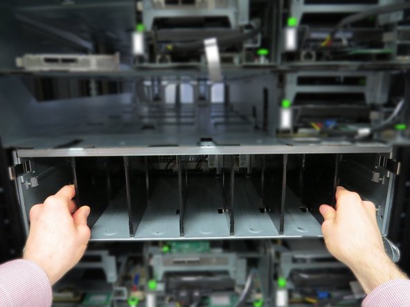 Locate and press two tabs on each side of the power shelf.