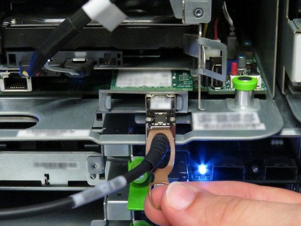 Disconnect the 10G SFP+ cable by pulling on the pull-tab, as shown.