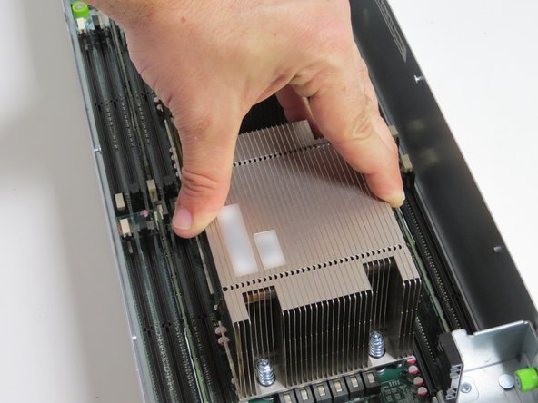 Pivot the heatsink forward so that the front two screw posts mate with the CPU retention post holes, as shown.