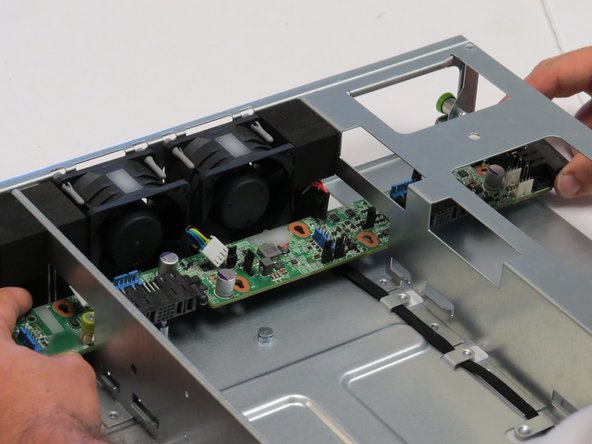 Pull the midplane board through the cutout located on the right side of the chassis, as shown.