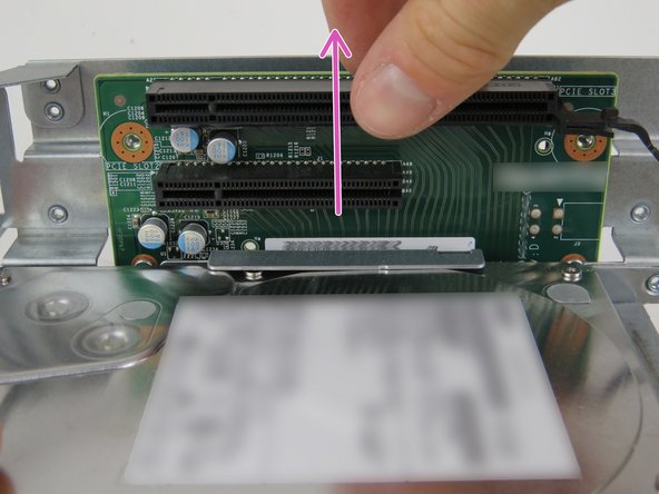 Slid the riser card upwards to release it from the metal cage studs.