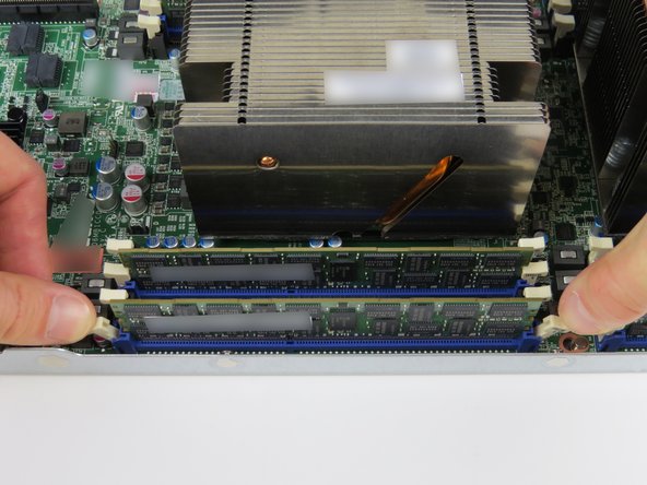 Press the (2) retention tabs on the DIMM slot which seats the failed DIMM.