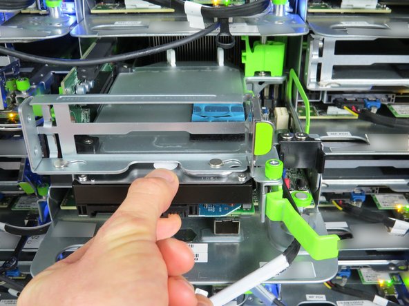 Carefully grab the center of the HDD to the right of the SATA cable connector to extend it from the PCIe cage.
