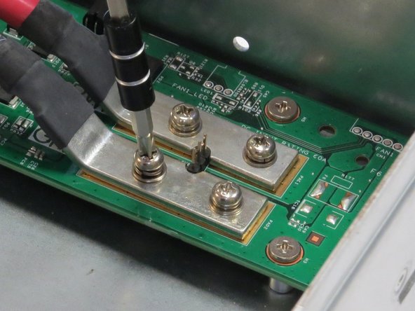 Unscrew four Phillips #2 screws that secure the bus bar leads to the fan controller board.