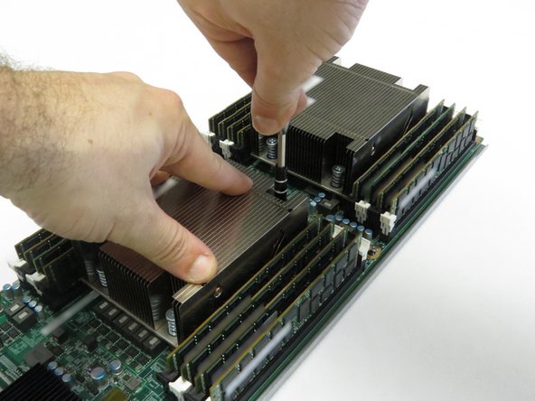 Using a cross-torque technique, loosen the Phillips #2 screws in a diagonal pattern to disconnect the CPU heatsinks from the motherboard.