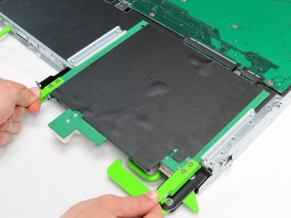 Pull the two tabs located on the front end of the expander board, as shown.