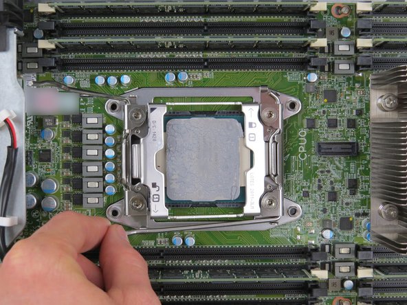 Press the first 'unlock' retention lever down towards the CPU to allow the CPU retention bracket to lift.