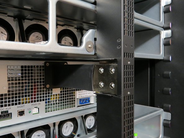 Make your way to the rear of the server rack to reconnect the output blade to the bus bar.