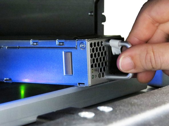 Lift the PSU so that it slides over the rack's rear Top of Rack (ToR) spacer.