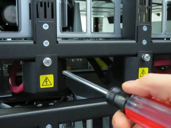 Loosen the three thumbscrews securing the bus bar lead shrouds to the rack.