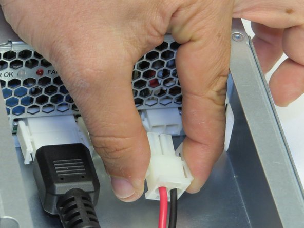 Disconnect one AC cable connector from the PSU.