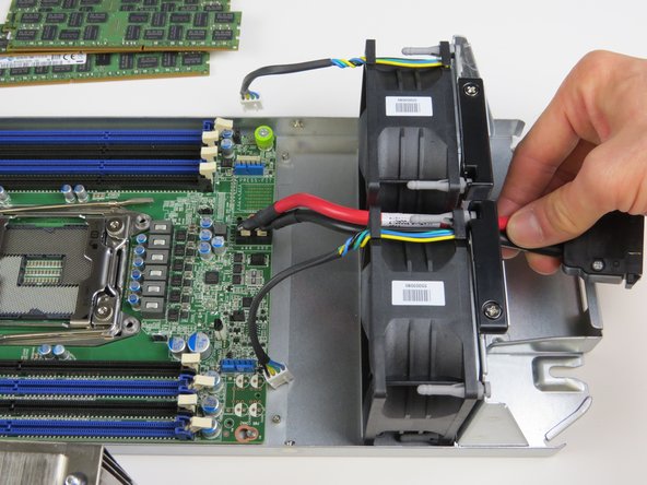 Carefully remove the motherboard power cable from in between the (2) fans as shown.