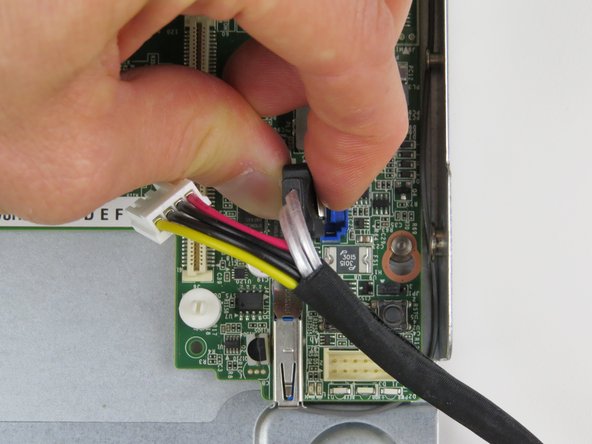 Disconnect the SATA cable by pressing the metal tab, then simultaneously lifting the connector upwards.
