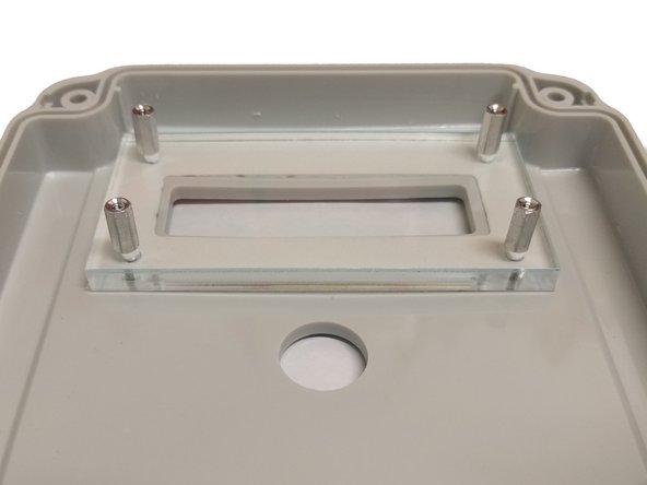 From the front place a 14mm screw through one of the small holes.