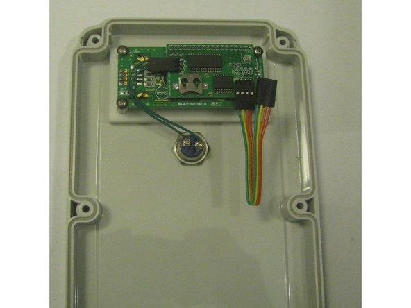 Fit the foam washers on the screws. Remove the protective film from the clear acrylic window and from the white nylon window brace. The metal spacers have a slight depression one end - the flat end goes down. Fit the screws to the case, then stack the rectangular foam seal, the clear window, the nylon brace, and the spacers.