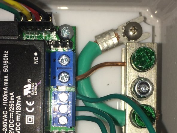 Crimp spade connector to the Green 10 AWG wire. Secure to enclosure base with the remaining 3/8" wide head screw and lock washer.