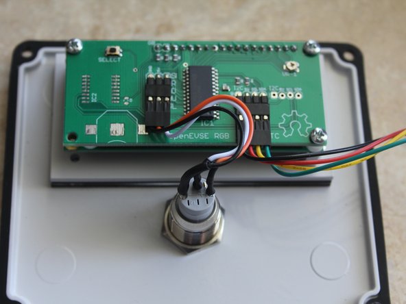 Mount the water resistant button switch to the enclosure lid. Seal should be placed on the outside. Tighten until seal expands.