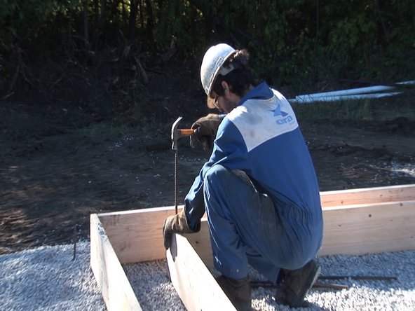 Once foundation is level and square, drive stakes into inner corners to keep the foundation in place. We used pieces of 1/2&quot; rebar for this, because we had lots on hand. You could also use wooden stakes.