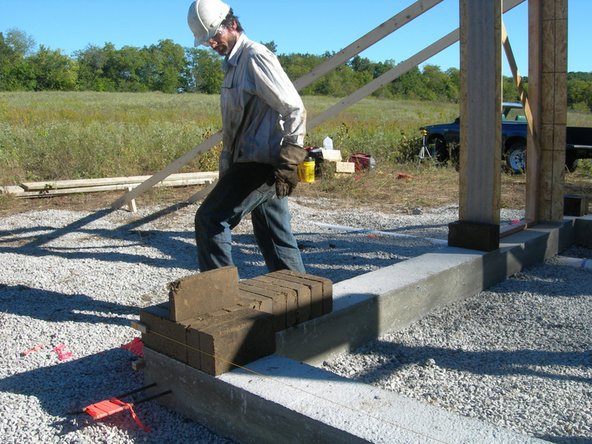 Once you have the corner blocks positioned precisely as described in the previous step, you are ready to attach the mason's blocks with strings, which will help you keep the walls straight as they go up.