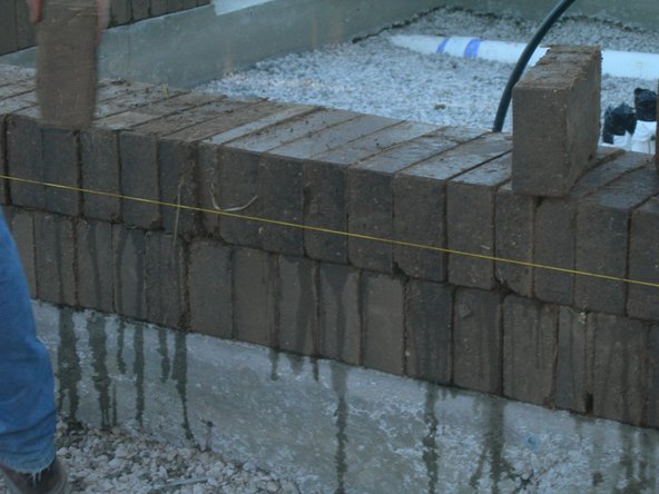 Make sure that as you lay the bricks, you are breaking the vertical joints. This means that bricks do not rest directly over the brick below them. One bricks rests on top of two bricks.