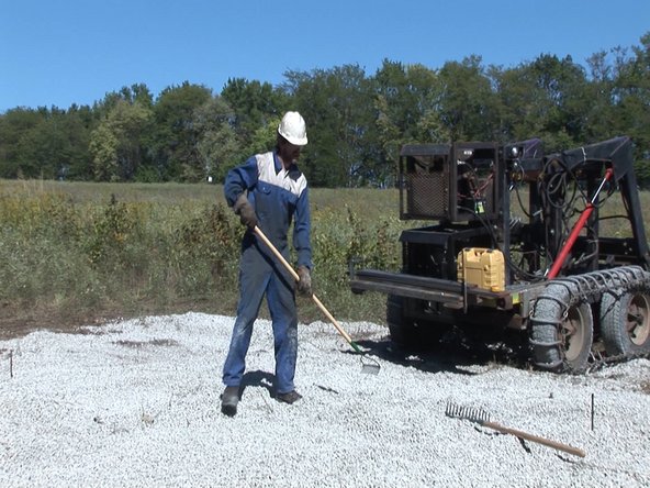 Flatten gravel into a level pad. The foundation formwork will be built on top of this pad.
