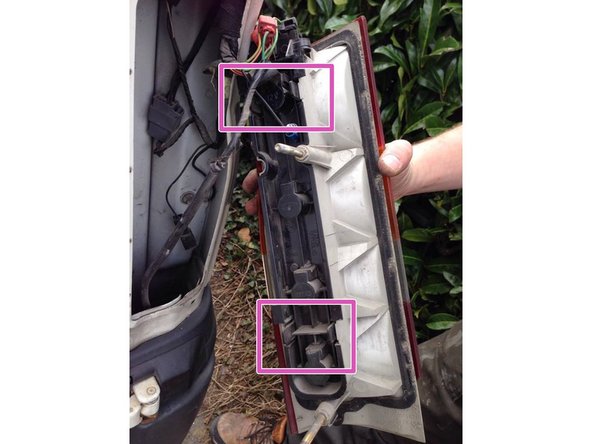 Présentez le cache en plastique noir dans le phare, puis appuyez fortement sur les deux clips disponible sur le cache, les clips sont sur le haut ainsi que le bas du cache des ampoules.