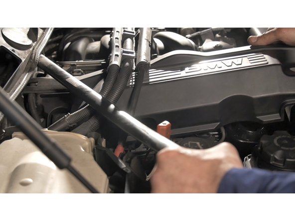 Soulever et tirer délicatement sur le cache moteur puis lever la barre pour faciliter le passage