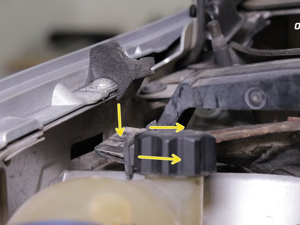 Retirer la  traverse en plastique en commençant par le coté conducteur puis appuyer sur la languette pour dégager le coté passager