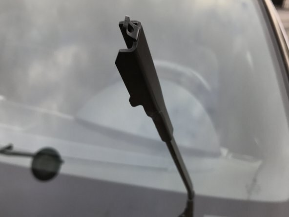 Positionner le crochet de l'essuie-glace dans la tête du balai (la flèche vous indique comment insérer le balai)