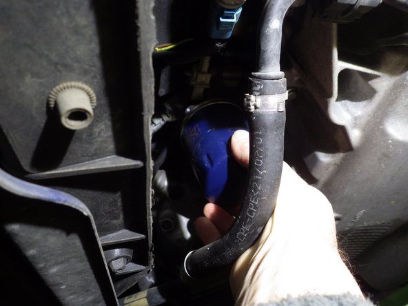 Mettre en place la clef à filtre en la positionnant pour le dévissage (rotation anti-horaire). Faire tourner la clef à oeil pour dévisser le filtre.